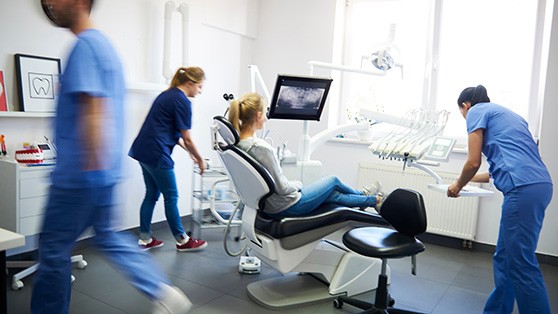 Blurred dentists treating a woman’s dental emergency