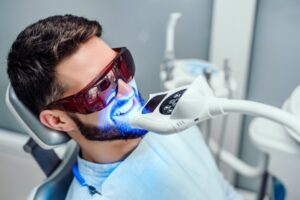 Man having teeth whitened at dentist. 