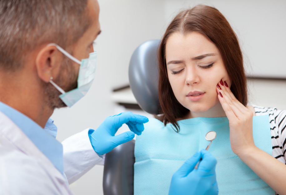 Patient holding jaw, talking to dentist