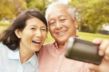 man who received dentures in Sunnyvale, CA smiling with his wife